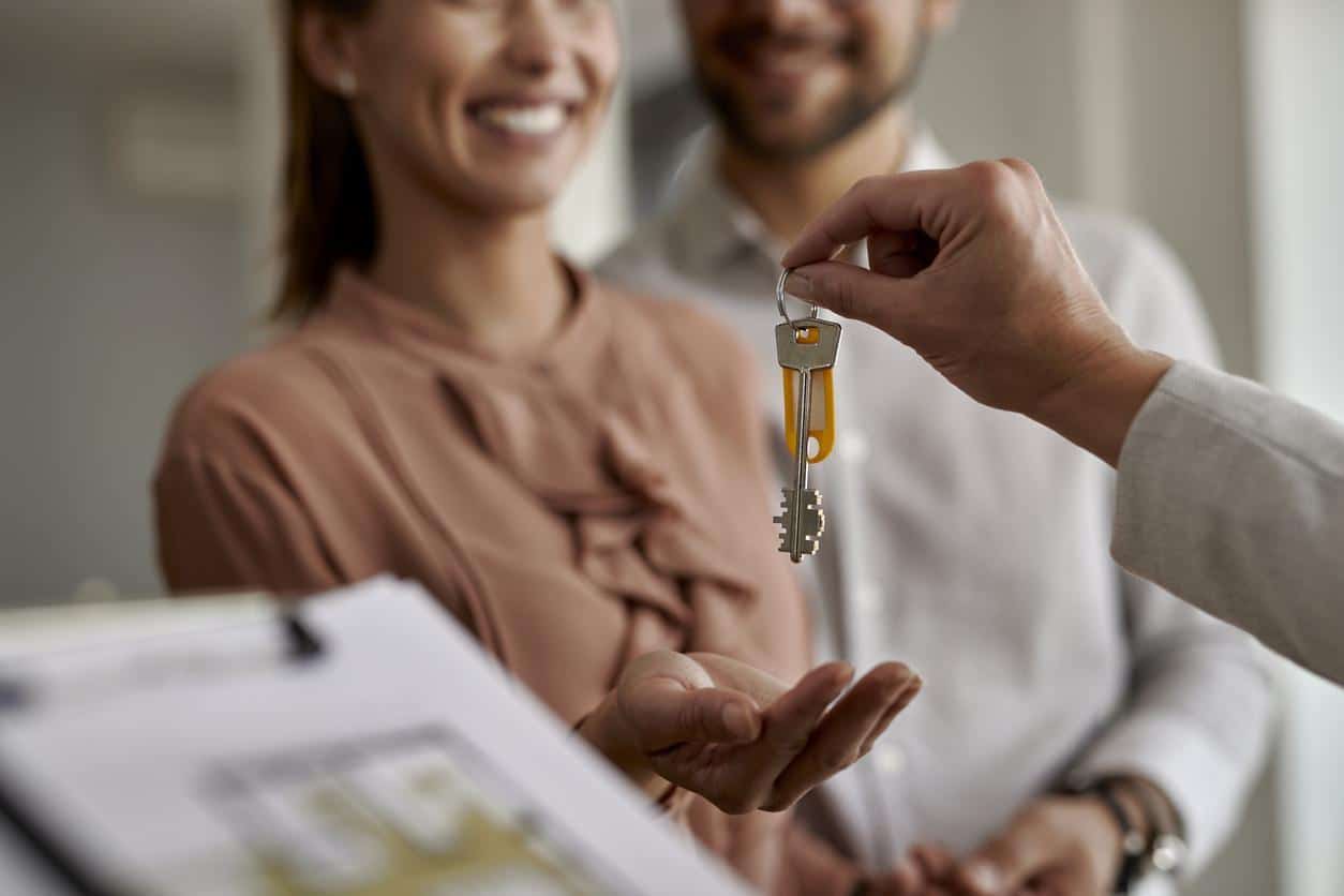 young couple being handed house keys on new-build home completion